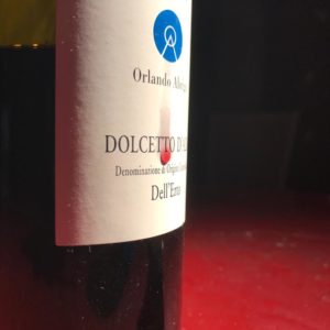 In primo piano etichetta di Orlando Abridolcetto d'Alba goccia di vino rosso